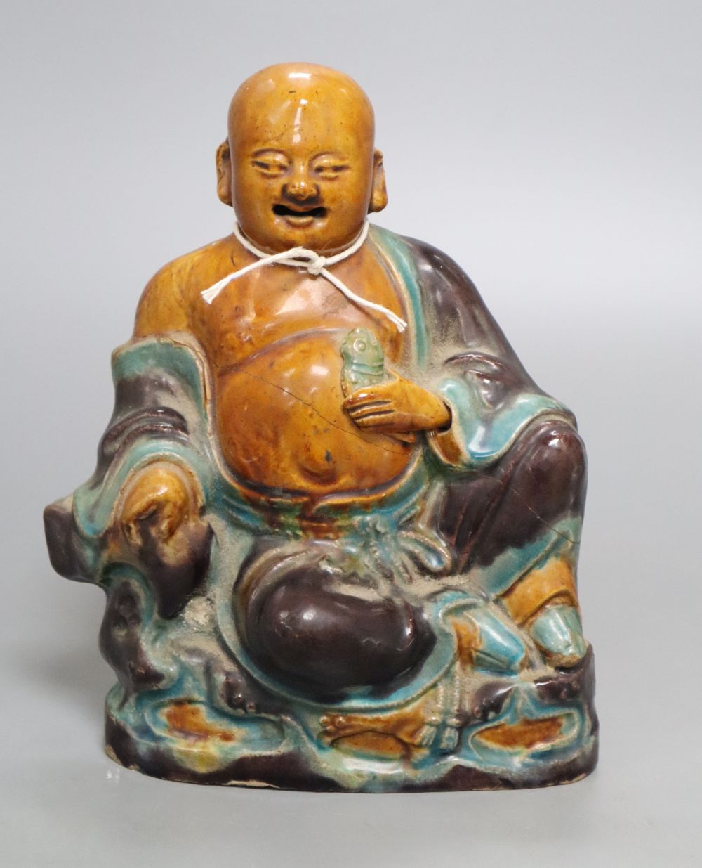 A Chinese Sancai pottery figure of a Budai, 18th/19th century, height 20cm